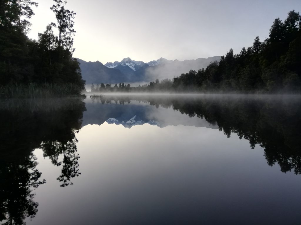 The morning dew rising over Lake Matheson